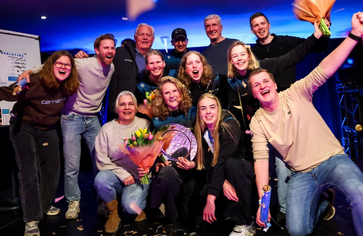 WhatsApp Image 2026-03-08 at 09.01.21 (1) Het marathonschaatsteam viert de winst in het ploegenklassement samen met sponsoren Puur ICT en BTZ. Een feestelijk moment met blije gezichten en trotse teamleden langs de baan.