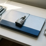 Zakelijke laptop beveiligd met stalen cijferslot op wit bureau, omringd door niet-gecertificeerde apparaten.