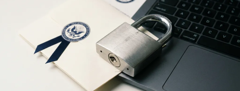 Stalen hangslot op laptoptoetsenbord met officieel document, symboliseert digitale gegevensbeveiliging en privacy.