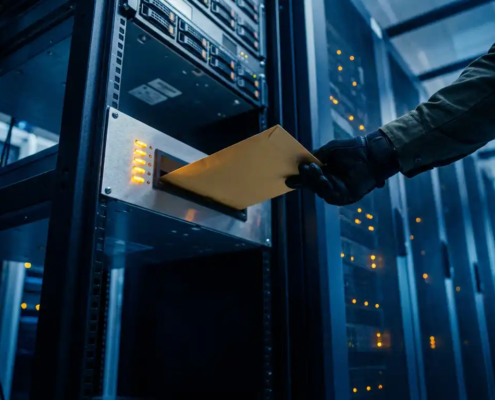 Gehandschoende IT-professional plaatst verzegelde envelop in serverzaal alertpaneel met knipperende amber lampjes en rackservers op de achtergrond.