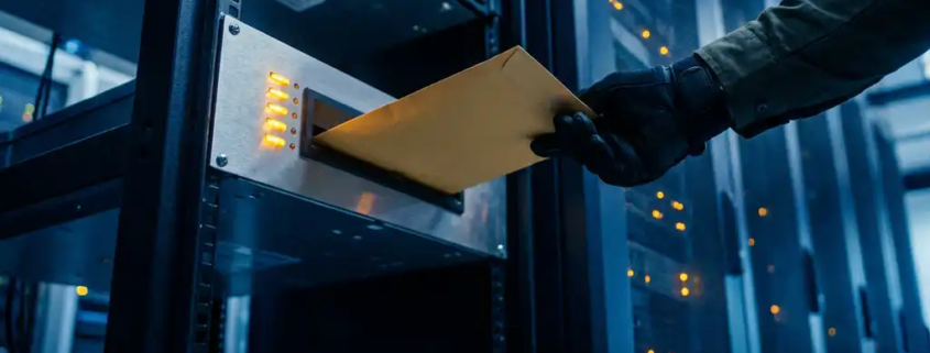 Gehandschoende IT-professional plaatst verzegelde envelop in serverzaal alertpaneel met knipperende amber lampjes en rackservers op de achtergrond.