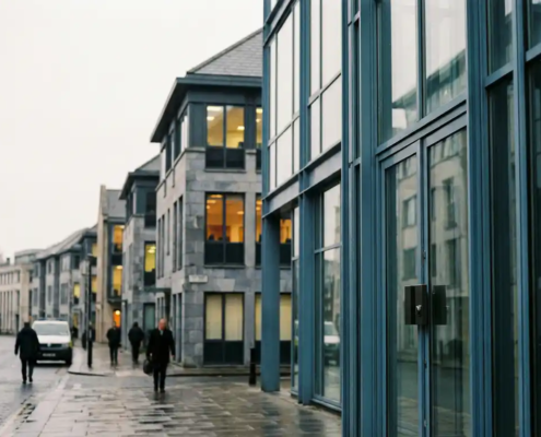 Rij verbonden kantoorgebouwen in staal- en grijstinten met beveiligingsslot op voordeur, symboliseert toeleveringsketenbeheer en regelgeving.