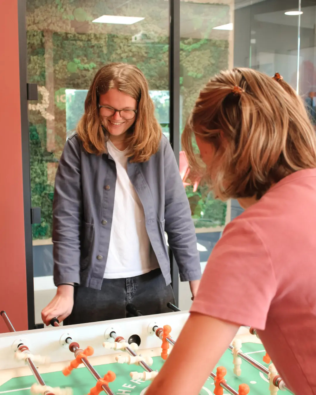 Twee collega’s van Puur ICT spelen samen een potje tafelvoetbal.