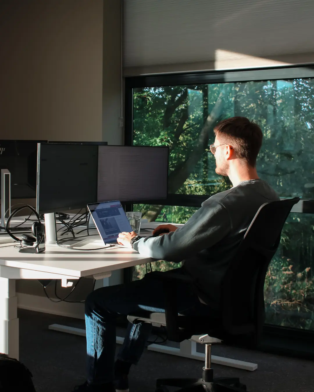 NIS2 & Digitale Weerbaarheid Een medewerker van Puur ICT zit achter zijn bureau en werkt op de computer.