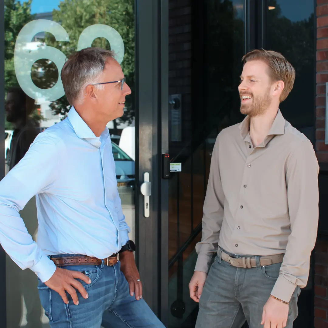 Slimmer Werken De twee eigenaren van Puur ICT staan voor het bedrijfspand en zijn met elkaar in gesprek.